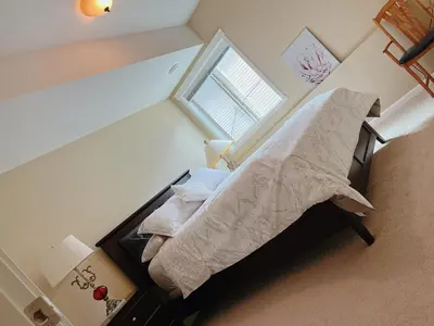 a small bedroom with a bed with a window at Peaceful and Spacious Lake View in West Kelowna