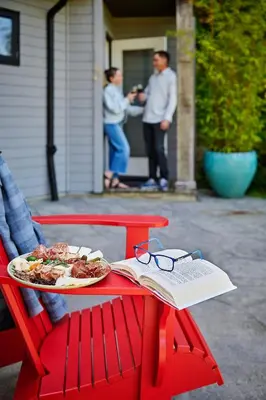 a plate of food on a red bench with a book at Liahona Guest House in Ucluelet
