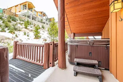 a porch with a bench and a hot tub at Trapper's Lodge - 4 Bd w Great View, Private Hot Tub in Big White