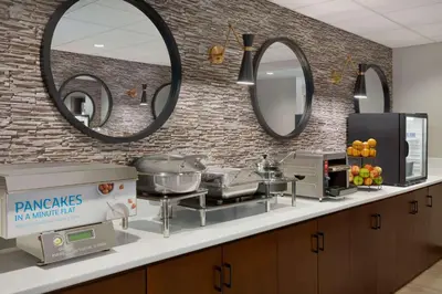 a kitchen with a counter with two sinks and mirrors at Microtel Inn & Suites by Wyndham Lloydminster in Lloydminster