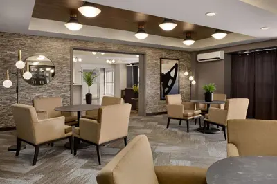 a waiting room at a hospital with tables and chairs at Microtel Inn & Suites by Wyndham Lloydminster in Lloydminster