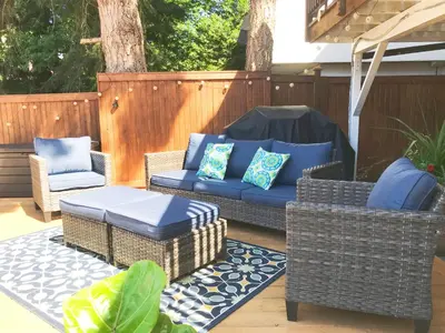 a patio with wicker chairs and a blue couch at walk distance to kits beach 2bedrooms only for you in Vancouver