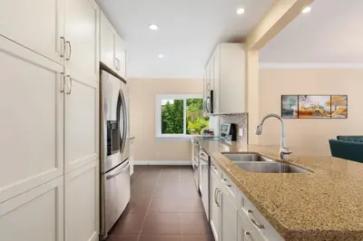 a kitchen with a sink and a refrigerator at LOVELY 3 bedroom PORT MOODY spacious home 6 people free parking in Port Moody