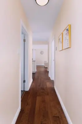 an empty hallway with white walls and wood floors at LOVELY 3 bedroom PORT MOODY spacious home 6 people free parking in Port Moody