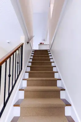 a staircase in a house with white walls and wooden stairs at LOVELY 3 bedroom PORT MOODY spacious home 6 people free parking in Port Moody