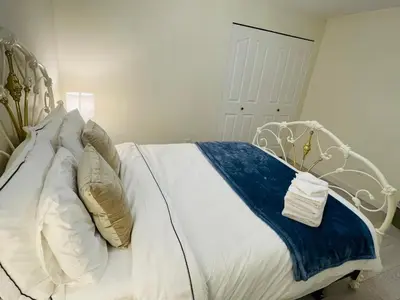 a bedroom with a white bed with a blue blanket at Adorable 2-Bedroom Basement in Vancouver in Vancouver