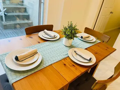 a wooden table with plates and napkins on it at Adorable 2-Bedroom Basement in Vancouver in Vancouver