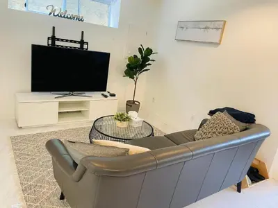 a living room with a couch and a tv at Adorable 2-Bedroom Basement in Vancouver in Vancouver