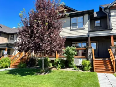 a house with a tree in the yard at Perfect base Invermere 3bd townhouse mt views with garage in Invermere
