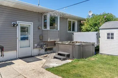 a backyard with a barbecue in front of a house at Bahama Breeze I Hot Tub I Pool I 5 Bedroom in Drumheller