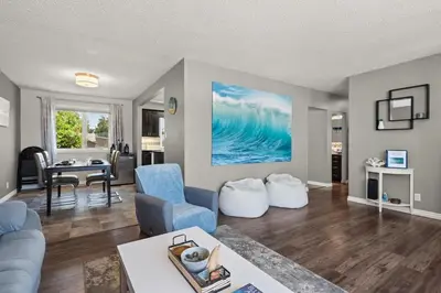 a living room with a blue couch and a table at Bahama Breeze I Hot Tub I Pool I 5 Bedroom in Drumheller
