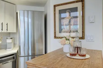 a kitchen with a table with two glasses on it at Victoria's Parliamentary Suite with Private Rooftop Patio & Harbour View in Victoria