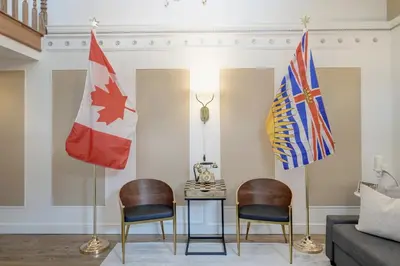 two flags in a living room with two chairs at Victoria's Parliamentary Suite with Private Rooftop Patio & Harbour View in Victoria