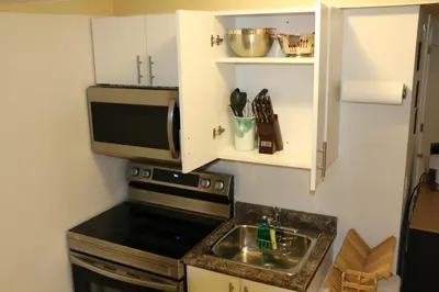 a small kitchen with a sink and a microwave at Guest Suite in Calgary in Calgary