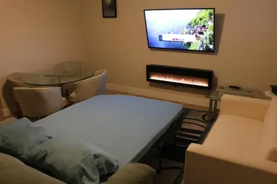 a room with a bed and a tv on a wall at Guest Suite in Calgary in Calgary
