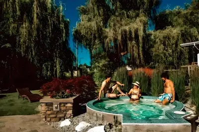 a group of people sitting in a swimming pool at Waterfront Oasis with Pool, Hot Tub & Pet Friendly in Kelowna