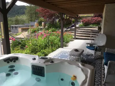 a bath tub sitting on a patio with a garden at Lakeview Gardens B&B in Peachland