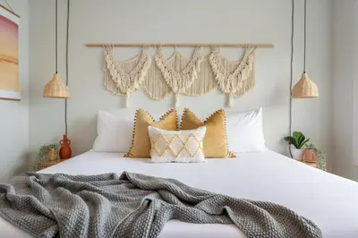 a bedroom with a white bed with gold pillows at The Promenade I Patio and BBQ I Fire pit I Sleep 9 in Sylvan Lake
