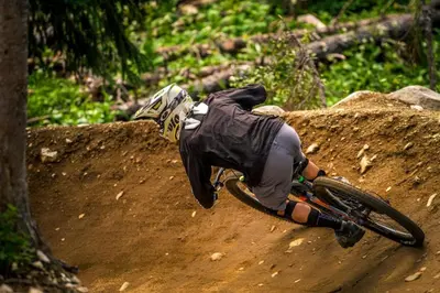 a person riding a bike on a dirt road at Bear's Paw Chalet - Amazing Location & Ski In-Out in Big White