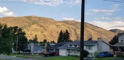 a mountain in the background of a town with houses at Charming - 2 bedrooms suite, 1 full bath & family room in Kamloops