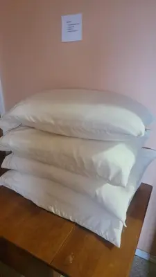 a stack of white pillows sitting on a table at Charming - 2 bedrooms suite, 1 full bath & family room in Kamloops