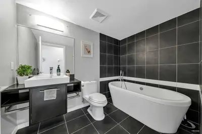 a bathroom with a tub and a toilet and a sink at Spacious DT 2-BDR High-rise with view, pool, gym in Vancouver