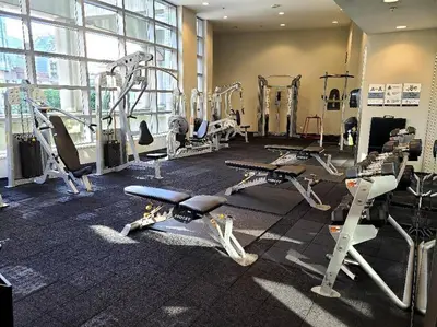 a gym with several treadmills and exercise bikes at Spacious DT 2-BDR High-rise with view, pool, gym in Vancouver