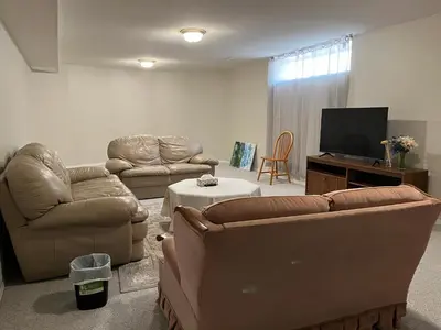 a living room with two couches and a flat screen tv at Licensed spacious basement suite with one king-size bed in Chilliwack