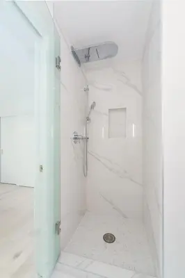 a white bathroom with a shower with a glass door at Steveston Village Bed and Breakfast in Richmond