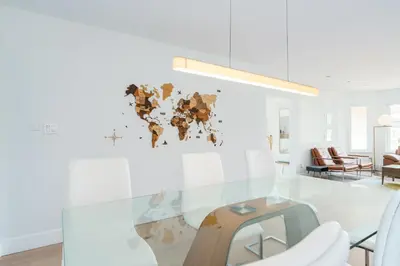 a room with a glass table with a world map on the wall at Steveston Village Bed and Breakfast in Richmond