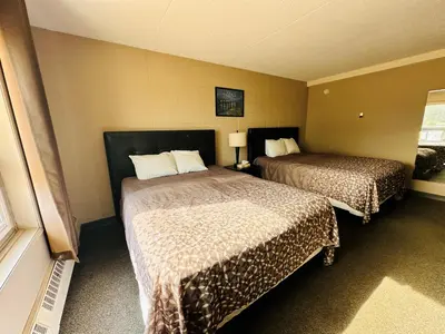 a hotel room with two beds in a room at Beaverlodge Motor Inn in Beaverlodge