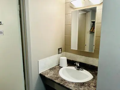 a bathroom with a sink and a mirror at Beaverlodge Motor Inn in Beaverlodge