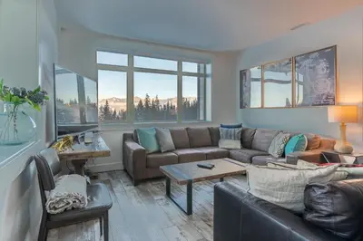 a living room with a couch and a table at Fully Renovated Ski-in/out Loft with Private Hot Tub! in Golden