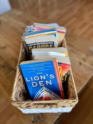 a basket full of books sitting on a table at Top Floor Riverfront Condo with Stellar Sunsets! in Fort McMurray