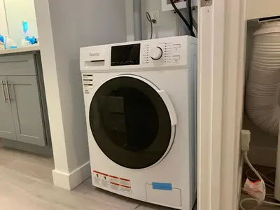 a white washing machine sitting in a room at A Romantic Studio with Full Kitchen & AC-141 in Canmore