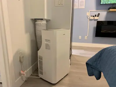 a refrigerator in a room next to a bed at A Romantic Studio with Full Kitchen & AC-141 in Canmore