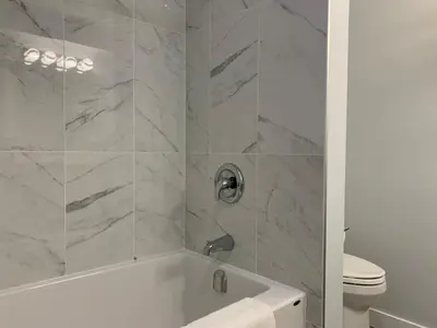 a white bathroom with a tub and a toilet at A Romantic Studio with Full Kitchen & AC-141 in Canmore