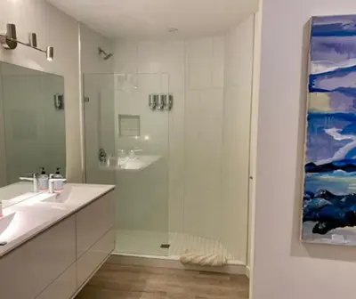 a white bathroom with a shower and a sink at J and Js in Bowen Island