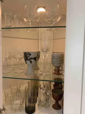 a glass shelf filled with glass wine glasses at Tiny House Big View in Chilliwack
