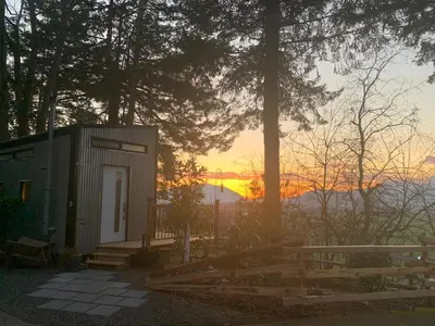 a small shed with a sunset in the background at Tiny House Big View in Chilliwack