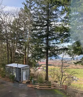 a small shed in a field with trees at Tiny House Big View in Chilliwack