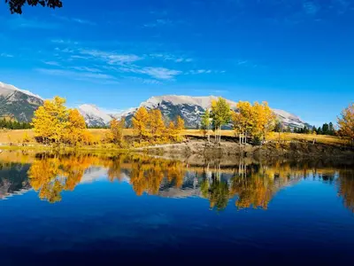 a lake with trees and mountains in the background at Romantic 1-Bedroom Serviced Apartment Kitchen & AC 143 in Canmore
