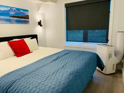 a bedroom with a bed and a large window at Romantic 1-Bedroom Serviced Apartment Kitchen & AC 143 in Canmore