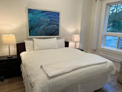 a bedroom with a large white bed with two lamps at Country home, Sleeps 6 pets friendly in Port Alberni