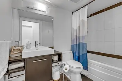 a bathroom with a sink and a toilet and a tub at Gastown Downtown Apartment very central in Vancouver