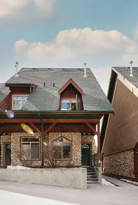 a house with a gambrel roof with a window at Mount Rundle Hideaway - Pool Hot Tub in Canmore