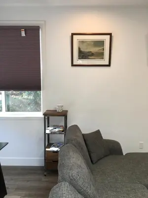 a living room with a couch and a window at The Purple Door Carriage House in Lantzville