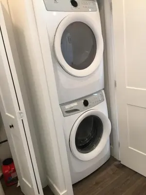 a washing machine in a bathroom with a mirror at The Purple Door Carriage House in Lantzville