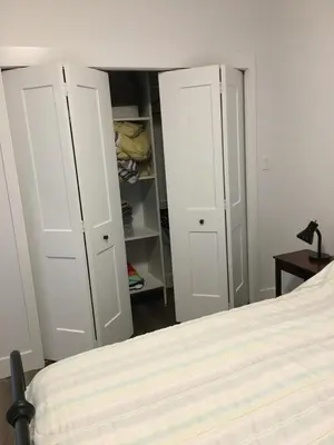 a bedroom with two white cabinets and a bed at The Purple Door Carriage House in Lantzville