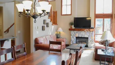 a living room with a table and a fireplace at Woodhaven #18 by Bear Country in Sun Peaks